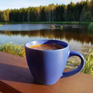 coffee on a railing by a lake square